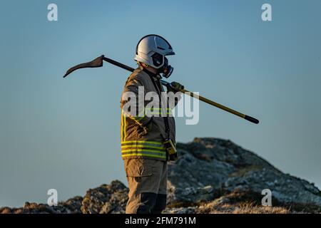 Feuerwehrmannschaften bekämpfen das Gorse-Feuer auf der Isle of Anglesey. Stockfoto