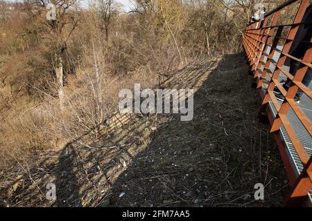 Ein steiler Hang in der Nähe der Aussichtsplattform in den Bergen, die natürliche Landschaft wird von Menschen verdorben, auf dem trockenen Gras im frühen Frühjahr bei sonnigem Wetter liegen CI Stockfoto