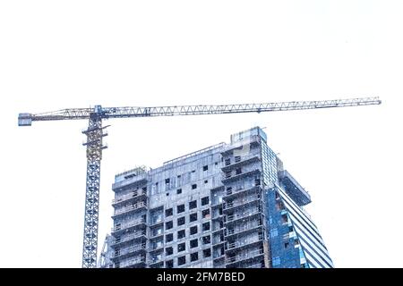 Turm Industriekran baut neue Betonstadt modernes Gebäude im Winter in Schnee und Kälte auf der Baustelle. Stockfoto