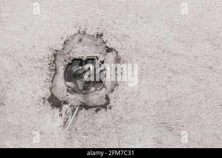 Nische für die Installation mehrerer Steckdosen an einer grauen Betonwand, Hausreparatur. Stockfoto