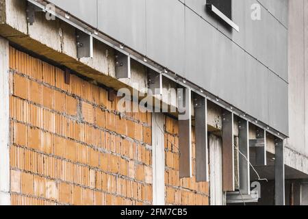 Fassadenreparatur Backsteinmauer eines neuen modernen unfertigen Gebäudes, Hochhaus-Rekonstruktion. Stockfoto