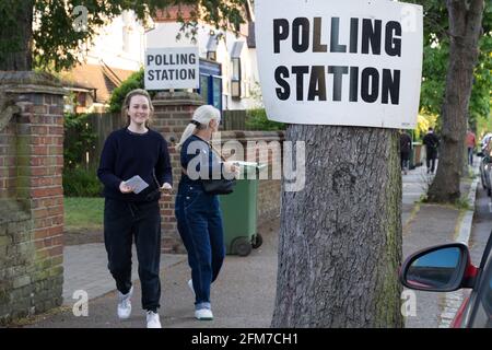 Zwei Wählerinnen verlassen am 6. Mai das Wahllokal für die britischen Wahlen 2021. „Super Thursday“, ein Wahlmonster Stockfoto