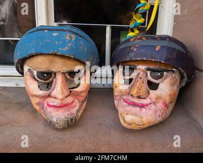 Zwei selbstgemachte Karnevalsmasken auf einer Fensterbank vor einem Haus in Basel, Schweiz Stockfoto