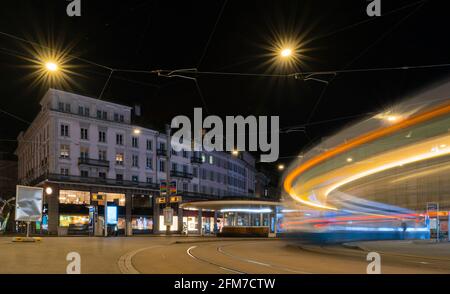 Leichte Trails einer Straßenbahn, die nachts am eintreffen Platz Paradeplatz in Zürich Stockfoto