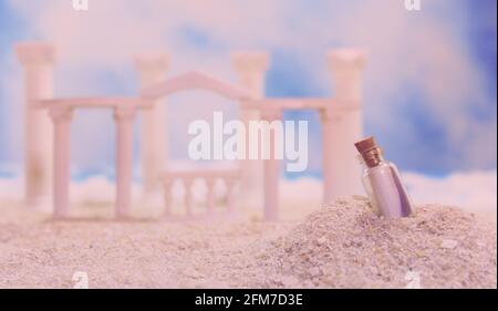 Tropischer Strand mit Ruinen im römischen Stil und Message in Bottle Stockfoto