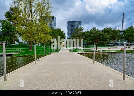 Schöne Fußgängerbrücke über einen ruhigen See im grünen Autostadt Park in Wolfsburg, Deutschland Stockfoto