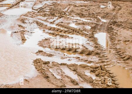 Spuren von Baufahrzeugen in Schlamm Sand und Pfützen an Eine Baustelle Stockfoto