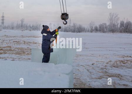 Der Slinger-Installierer legt ein Klebeband-Lappen-Seil auf den Haken Stockfoto