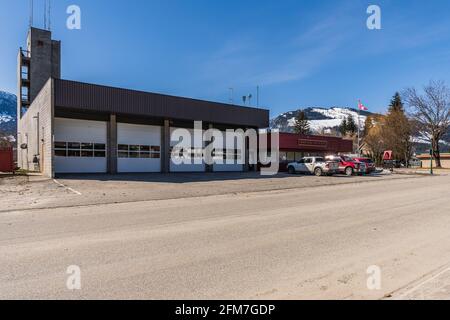 REVELSTOKE, KANADA - 16. MÄRZ 2021: Blick auf die Feuerwehrhalle der kleinen Stadt mit Autos und kanadischer Flagge. Stockfoto