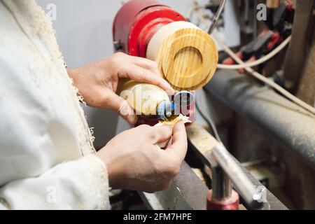 Tischler in seiner Werkstatt benetzen Stoffstück mit Holz Polier- und Färbeflüssigkeit Stockfoto