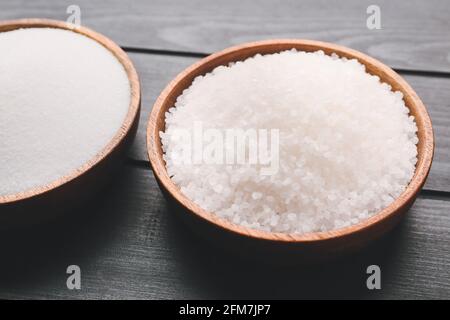 Schalen mit verschiedenen Salz auf dunklem Holzhintergrund Stockfoto