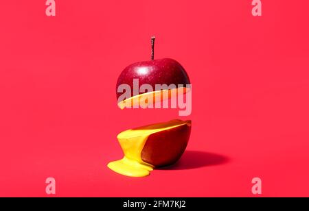 Roten Apfel mit Flüssigkeit auf farbigem Hintergrund schneiden Stockfoto