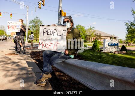 Bloomington, Usa. Mai 2021. Ein Demonstrator hält ein Plakat, auf dem die Menschen während der Demonstration über Profit stehen. Protestierende, die vom Oxfam Club der Indiana University organisiert wurden, nehmen an der „Free the Vaccine“-Demonstration vor Catalent Teil. Die Demonstranten fordern ein Ende der Impfpatente und die kostenlose Bereitstellung von Impfstoffen für die ganze Welt. Die Impfstoffe von Moderna, Johnson und Johnson sowie Pfizer werden in der Catalent-Fabrik in Bloomington hergestellt. Kredit: SOPA Images Limited/Alamy Live Nachrichten Stockfoto