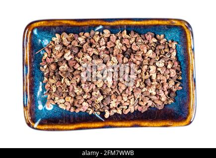 Draufsicht auf getrockneten rosa sichuanpfeffer auf rechteckigem Teller Ausschnitt auf weißem Hintergrund Stockfoto