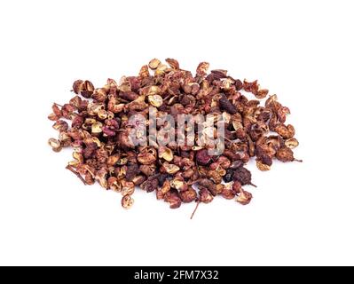 Stapel getrockneter rosafarbener sichuan-Pfeffer aus der Nähe auf weißem Hintergrund Stockfoto