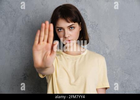 Wütend seriöse junge Frau zeigt Stop-Geste isoliert über grau Hintergrund Stockfoto