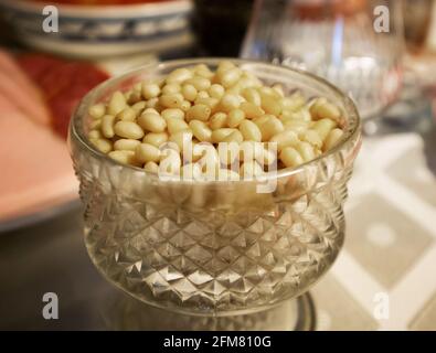 Stapel geschälte Kerne von Zedernnüssen in einer geriffelten Kristallvase Stockfoto