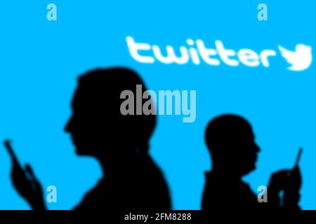 Taschkent, Usbekistan - 4. März 2021: Silhouette der Menschen über beliebte Microblogging und Social-Networking-Service - Twitter-Logo auf einem großen Stockfoto