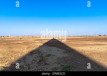 Zwei Mann, der von diesem Jeep springt und hinter ist Windmühle in jaisalmer Bereich von rajasthan. Stockfoto