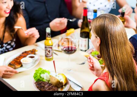 Freunde oder Paare Fast-Food Essen und trinken Bier und Wein in einem amerikanischen Fast-Food-Imbiss Stockfoto