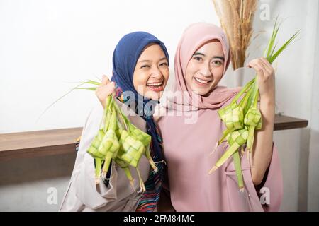 Aufgeregt asiatische muslimische Frau Herstellung Ketupat Reis Stockfoto