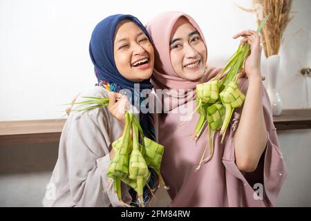 Aufgeregt asiatische muslimische Frau Herstellung Ketupat Reis Stockfoto