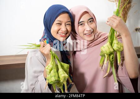 Aufgeregt asiatische muslimische Frau Herstellung Ketupat Reis Stockfoto
