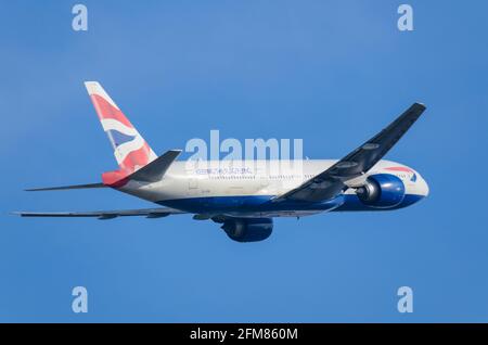 British Airways Boeing 777-Düsenflugzeug G-VIIH steigt nach dem Start vom Flughafen London Heathrow, Großbritannien, aus. Halten Sie die Flagge fliegen patriotischen Slogan Stockfoto