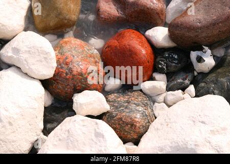 Nahaufnahme von bunten, nassen Steinen, Kreide und Kies an der Steilküste der Ostsee auf Rügen, Deutschland Stockfoto