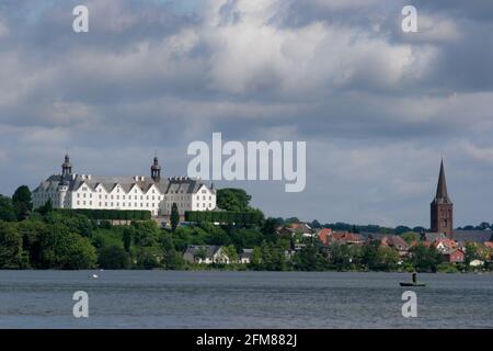 Seeblick auf das schöne Schloss und die Kirche von Plön, Deutschland mit bewölktem Himmel im Hintergrund und Sonne scheint auf dem Wahrzeichen Stockfoto