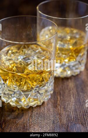 Draufsicht auf zwei Gläser mit Whiskey mit Eis auf dunklem Holztisch, vertikal, mit Kopierraum Stockfoto