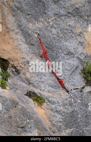 Kletterseil und Anker, die an einer natürlichen Felswand hängen gelassen wurden. Stockfoto