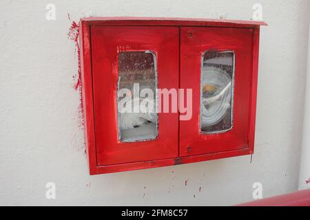 Feuerwehrschlauch an der Wand in einem modernen Gebäude Stockfoto