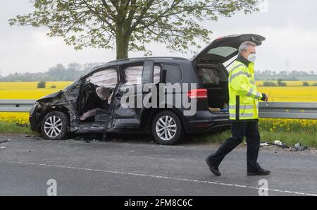 Sehnde, Deutschland. Mai 2021. Nach einem Unfall auf dem L410 in der Region Hannover wird ein schwer beschädigtes Auto geparkt. Am Morgen, nach ersten Informationen, fuhr ein öffentlicher Bus in entgegenkommenden Verkehr und kollidierte mit dem Auto. Es gibt mehrere Verletzte, darunter auch Kinder. Quelle: Julian Stratenschulte/dpa/Alamy Live News Stockfoto