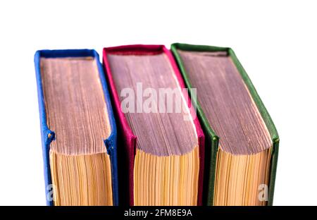 Drei alte Bücher, die nach hinten gedreht wurden, wurden auf weißem Hintergrund Nahaufnahmen gemacht. Stockfoto
