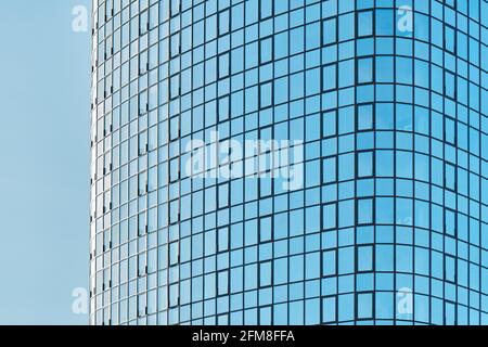 Stilvolles Bürogebäude in einem Hochhaus mit einer glänzenden blauen Glasfassade Helles Sonnenlicht gegen klaren blauen Himmel an sonnigen Tagen Stockfoto