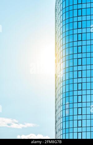 Stilvolles Bürogebäude in einem Hochhaus mit einer glänzenden blauen Glasfassade Helles Sonnenlicht gegen klaren blauen Himmel an sonnigen Tagen Stockfoto