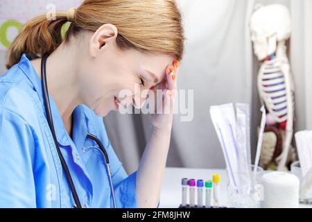Eine Ärztin mittleren Alters arbeitet an einem Laptop. Arztpraxis, medizinische Geräte. Stockfoto