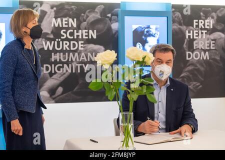 07. Mai 2021, Bayern, München: Markus Söder (CSU), Ministerpräsident von Bayern, unterzeichnet nach einem Gedenkgottesdienst an der Ludwig-Maximilians-Universität zu Ehren von Sophie Scholl das Goldene Buch. Links steht Hildegard Kronawitter, 1. Vorsitzende des Weisse Rose e.V. Sophie Scholl war Mitglied der Widerstandsgruppe "Weiße Rose" und wäre am 9. Mai 100 Jahre alt geworden. Die Weiße Rose prangerte die Verbrechen der Nazis an und verteilte Flugblätter, um die Menschen aufzurütteln. Am 18. Februar 1943 wurden Hans und Sophie Scholl während einer Aktion in München verhaftet und vier Tage später hingerichtet. Foto: Peter Kneff Stockfoto