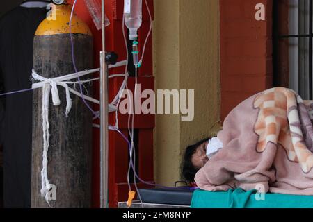 Kathmandu, NE, Nepal. Mai 2021. Eine Frau, die sich einer Sauerstoffversorgung unterzieht, ruht sich wegen fehlender Betten vor einem Covid-19-Krankenhaus in Kathmandu, Nepal, 7. Mai 2021 aus. Quelle: Aryan Dhimal/ZUMA Wire/Alamy Live News Stockfoto