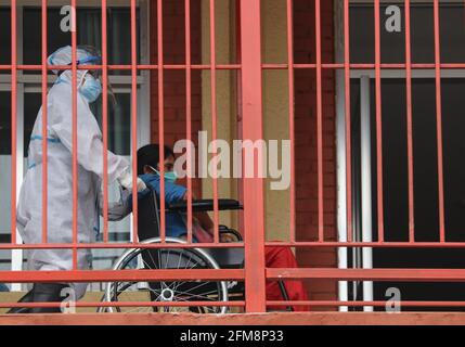 Kathmandu, NE, Nepal. Mai 2021. Ein Gesundheitsmitarbeiter schiebt einen Covid-19-Patienten in einen Rollstuhl in ein Krankenhaus in Kathmandu, Nepal, 7. Mai 2021. Quelle: Aryan Dhimal/ZUMA Wire/Alamy Live News Stockfoto