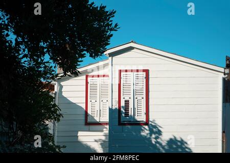 Außen und zwei Fenster eines schönen alten Holzhauses Mit einer Perspektive Stockfoto