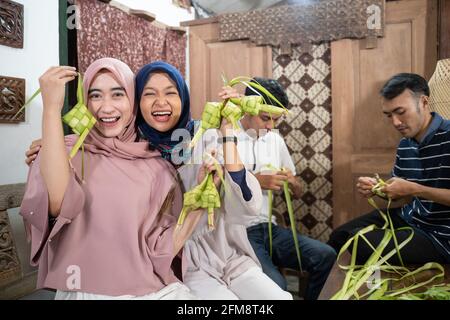Aufgeregt asiatische muslimische Frau Herstellung Ketupat Reis Stockfoto