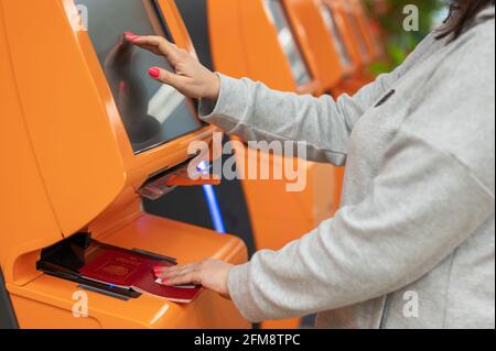 Reisende, die am Flughafen einen Automaten-Check-in-Automaten nutzen, Nahaufnahme auf dem Display, Anwendung zur Bestätigung der Buchungsdetails. Frau Stockfoto