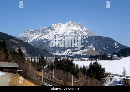 Österreich, Schienen und schneebedecktes Dorf Hochfilzen, Leoganger Steinberge im Hintergrund Stockfoto