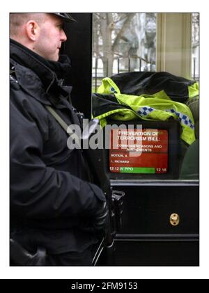 Bewaffnete Polizisten stehen Wache vor dem Unterhaus A Der TV-Bildschirm aktualisiert die Sicherheit, während die Anti-Terrorismus-Gesetzgebung diskutiert wird Im parlament in London.pic David Sandison 11/3/2004 Stockfoto