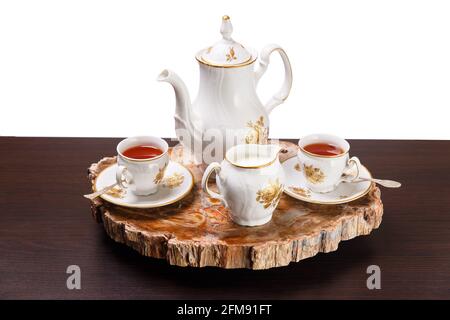 Elegantes Kaffeeset auf einem exklusiven Tablett aus einem Schnitt aus altem versteinertem Holz Stockfoto