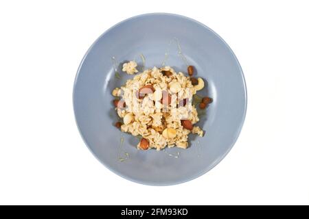 Draufsicht auf leckeren und appetitlichen Haferbrei mit getrockneten Früchten und Rosinen, Nüssen auf weißem Hintergrund. Konzept von köstlichem und gesundem Haferbrei zur Aufrechterhaltung des Körpergewichts oder der Ausmaschung. Stockfoto