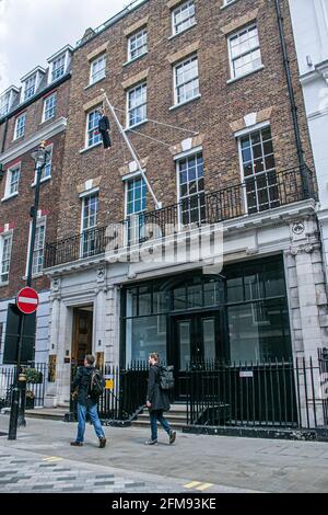 SAVILE ROW LONDON 7. MAI 2021. Eine Skulptur des italienischen Künstlers Maurizio Cattelan eines Mannes, der einen Blumenstrauß in der Savile Row London an einer Schlinge an einem Fahnenmast hält. Credit amer Ghazzal/Alamy Live News Stockfoto