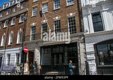 SAVILE ROW LONDON 7. MAI 2021. Eine Skulptur des italienischen Künstlers Maurizio Cattelan eines Mannes, der einen Blumenstrauß in der Savile Row London an einer Schlinge an einem Fahnenmast hält. Credit amer Ghazzal/Alamy Live News Stockfoto